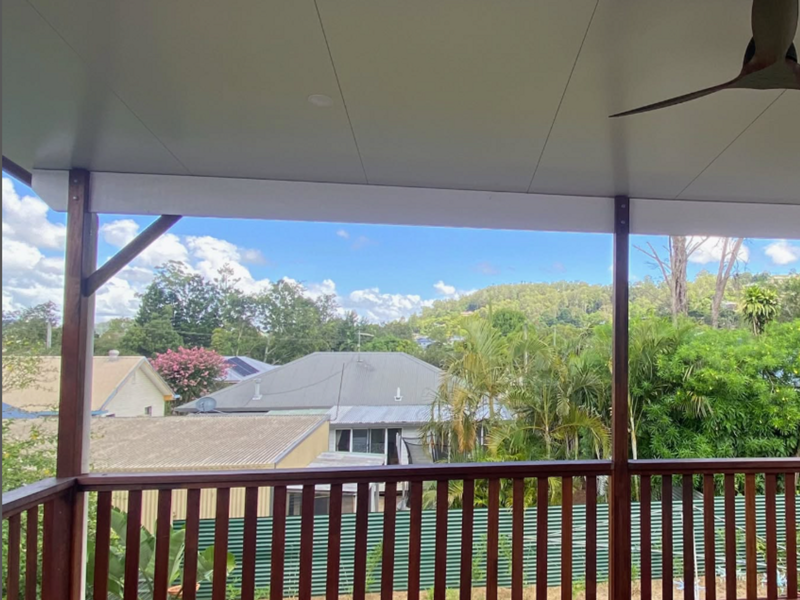 A covered verandah looking out over the treetops and rooftops